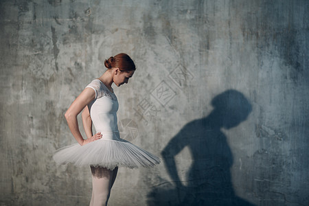 年轻美丽的芭蕾舞女舞蹈家 穿着专业服饰 指尖鞋和白色的礼服 (笑声)背景图片