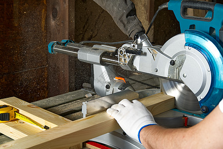 在木工车间使用电动圆锯的专业橱柜制造商的特写镜头 熟练的木匠用圆锯切割木板 木质材料生产 木材厂零售商锯板桌子标志男性力量锯床工图片