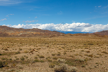 伊塞克库勒湖地区山顶的白云顶峰荒野远足高地岩石草原风景天空国家太阳图片