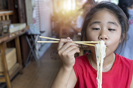 穿红裙子的亚洲女孩吃小面条汤C面条幸福筷子桌子午餐乐趣食物男人餐厅成人图片