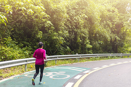 早上有粉红色长袖女人在路上跑来跑去跑步慢跑者成人运动装街道男性男人森林速度阳光图片