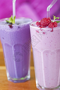 两杯新鲜果汁饮料玻璃稻草覆盆子奶昔水果背景图片