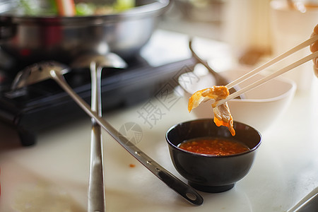 英俊男人把肉和猪肉 滑到热锅里美食烹饪菜单海鲜蔬菜盘子餐厅午餐烧烤牛肉图片