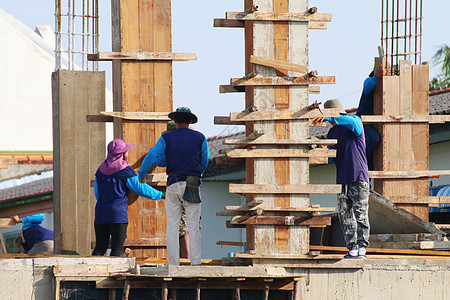 建筑工地和建筑工人区 人们正在施工 一群人是专业建筑工人 劳工工人劳动力蓝色水泥框架头盔团体梯子房子劳动建筑学图片