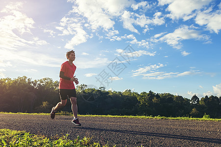 英俊的年轻男子在一条农村公路上跑来跑去追求良好的健康训练跑步小路树木速度行动活动男性日落慢跑者图片