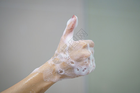 肥皂中软泡沫泡沫的手举起拇指图片