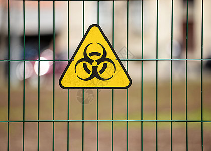 绿色装饰性金属铁丝栅栏上的生物危害警告标志图片