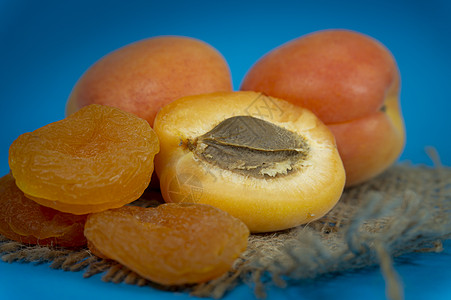 干燥的杏子 新鲜的整顿和半分一半的杏子甜点水果团体桌子乡村食物健康种子饮食麻布图片
