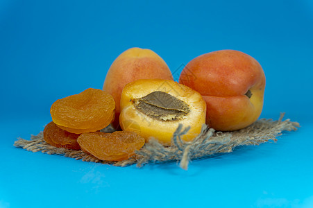 干燥的杏子 新鲜的整顿和半分一半的杏子麻布甜点营养桌子农业水果果汁种子正方形团体图片