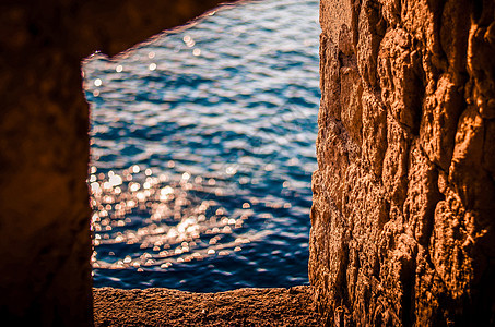 城堡废墟 旧石墙的窗户 海水中太阳光线的反射图片