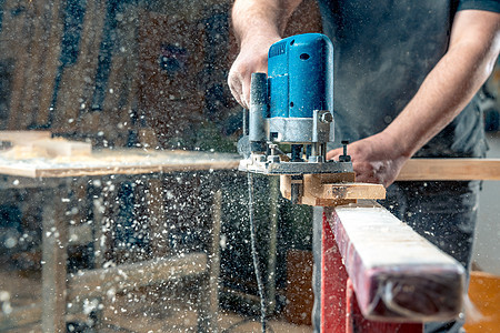 使用人工机械切割机在木房里磨木头 空中飞翔的锯尘 复制空间图片