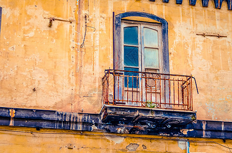 意大利一个老旧的废弃和腐烂房屋外墙上的古老阳台图片