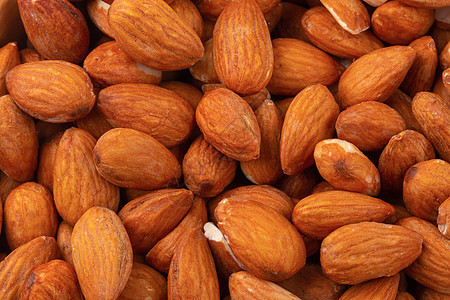 以白色背景隔离的木碗中的杏仁饮食营养棕色团体水果食物小吃核心坚果种子图片