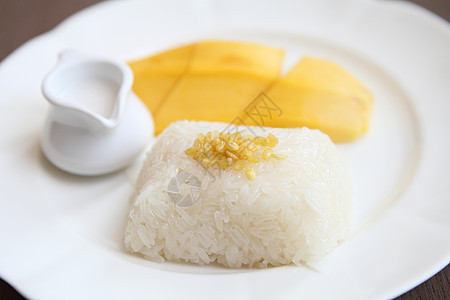 与芒果在木材背景上的粘黏性稻米饮食美食水果牛奶午餐甜点文化营养热带坚果图片