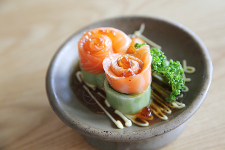含黄瓜的鲑鱼生西米和木头上的黄瓜海鲜筷子蔬菜餐厅寿司美食鱼片红色食物盘子图片