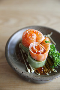 含黄瓜的鲑鱼生西米和木头上的黄瓜桌子鱼片红色筷子食物餐厅寿司盘子蔬菜美食图片