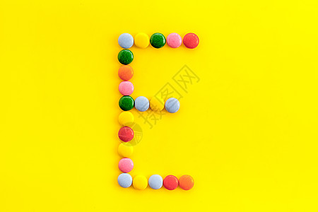 字母 E-从上面用黄色糖果制成的字母表图片