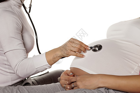 医生倾听孕妇的听诊器胃部 并听到怀孕肚子孩子母亲子宫父母医院白色产妇女性图片