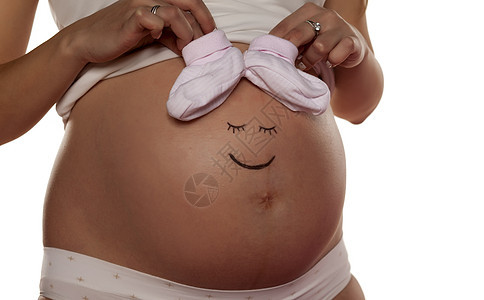 孕妇在肚子上装着笑容的笑脸女性母性父母孩子身体女孩白色幸福婴儿女士图片