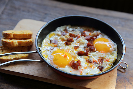 带热锅的炸鸡蛋桌子烹饪气体早餐厨房木头火炉食物香肠盘子图片