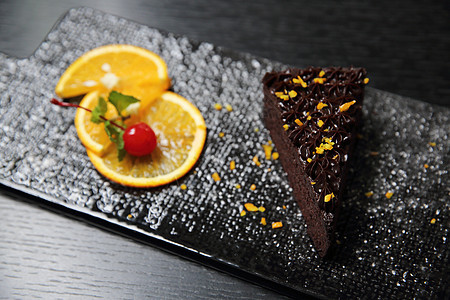 以木本为背景的橙色巧克力蛋糕盘子装饰甜点馅饼橙子木头巧克力面包可可烹饪图片
