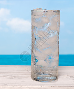 白木板上加冰的清新饮用水杯wi口渴气泡玻璃海洋茶点饮料苏打天空蓝色阳台图片