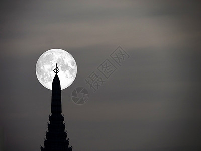 夜空中的超月亮和古代塔台顶的休眠图片