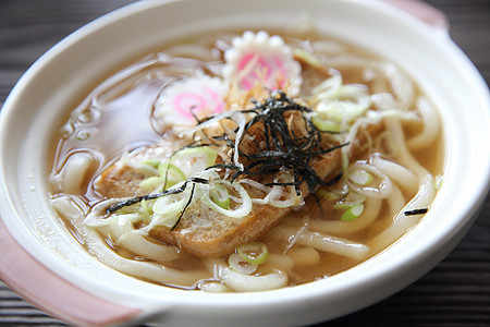 日本食品乌冬面拉面盘子餐具筷子桌子韭葱面条煮沸蔬菜粮食店铺背景图片