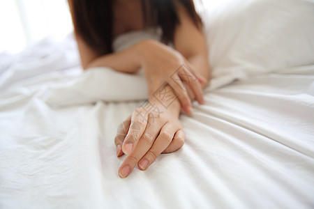 关紧年轻的年青女人的手放在床上手指拇指女性皮肤女孩卧室成人指甲白色手臂图片