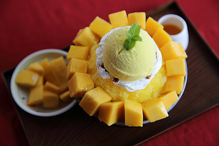 与新鲜芒果一起的雪冰甜点勺子白色乳白色盘子美食食物牛奶奶油糖浆胡子图片