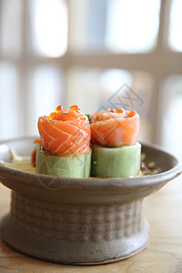 含黄瓜的鲑鱼生西米和木头上的黄瓜美食桌子盘子蔬菜筷子鱼片橙子红色寿司食物图片