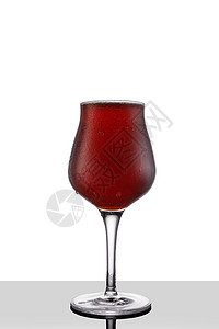 白底孤立的郁金香葡萄酒杯中的红啤酒图片