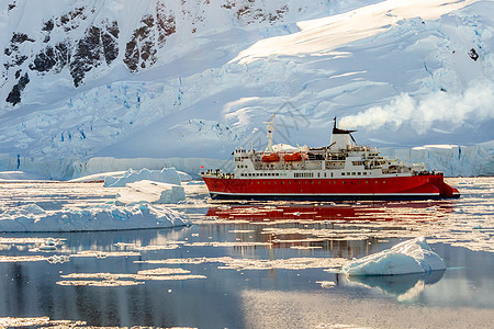 红色游轮蒸汽船漂流在冰山之间 岩石巨大旅游顶峰衬垫甲板汽船环境场景编队巡航太阳图片