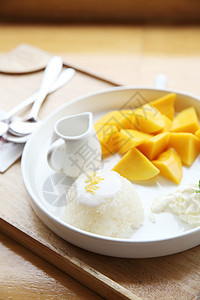 与芒果在木材背景上的粘黏性稻米美食午餐叶子牛奶热带甜点营养水果坚果文化图片