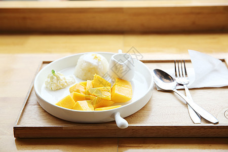 与芒果在木材背景上的粘黏性稻米甜点坚果牛奶热带叶子文化营养午餐水果食物图片