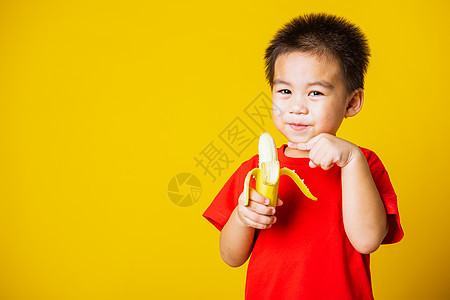 穿着红色T恤运动的笑容 可爱可爱的小男孩童年微笑食物快乐男生香蕉孩子工作室维生素头发图片