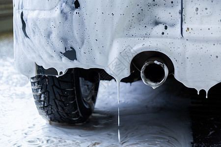 在室内洗衣时用肥皂泡沫覆盖的矿物燃料车     以有选择的重点从后面近距低角度观察车辆自助技术气泡洗车服务车轮房间运输汽车图片