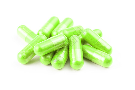 在白背景特检上以选择性焦点隔离的ufo绿色有机胶囊堆植物维生素胶囊食物药品饮食药物药店药片粉末图片