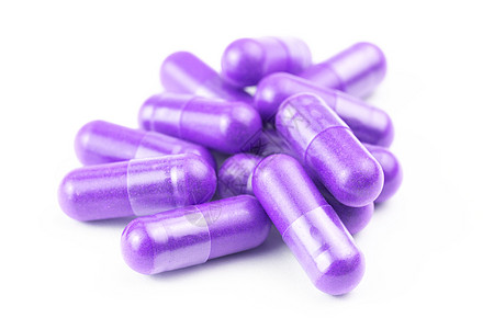 在白背景特检上以选择性焦点隔离的质子紫色有机胶囊堆积维生素治疗宏观粉末制药食物饮食药店团体植物图片