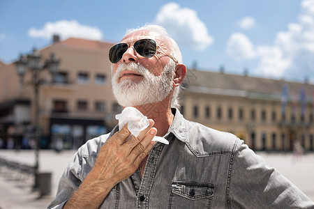 老人打扫脖子和汗水 在户外用热苏擦湿棉布毛巾退休垃圾清洁工男人塑料人体组织部位图片