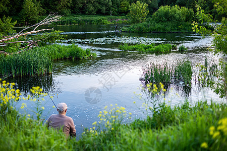 在夏日白天与朋友在河边钓鱼 有选择性地集中注意力图片