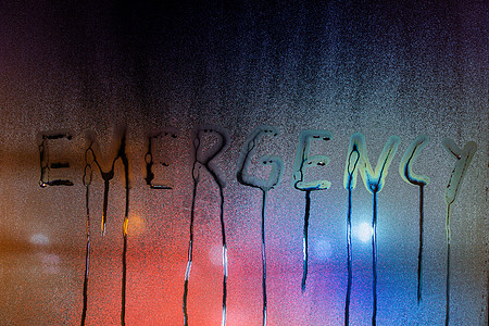 夜间湿窗玻璃上写的“紧急”一词 特写模糊背景图片