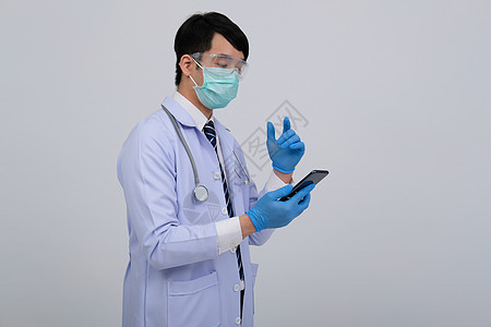 身戴智能电话和口罩的医生医生执业医师药品白色医院面具医疗保险手套领带眼镜乐器测量图片