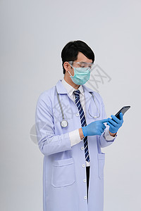 身戴智能电话和口罩的医生医生执业医师工作医疗卫生保健乐器手机面具眼镜领带药品图片