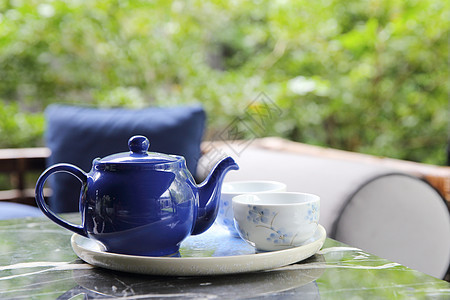 把茶倒在茶杯里 紧贴中国和日本的饮料中茶壶草本植物液体茶点杯子绿茶茶碗食物陶器芳香图片