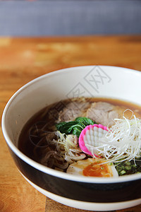 以木本为背景的日本菜大豆面条肉汤韭菜筷子美食烹饪食物芝麻午餐图片