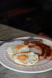 早餐英语鸡蛋香肠和培根蛋黄猪肉油炸黑色桌子餐厅黄色午餐盘子熏肉图片