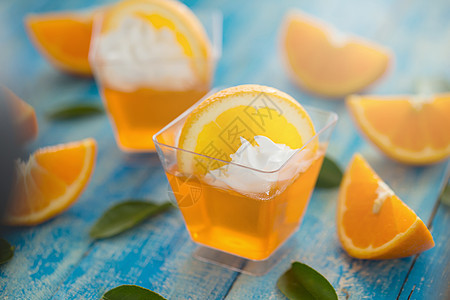 杯子中的橘子果冻加奶油和橙汁水果活力黄色食物热带叶子果汁橙子绿色图片