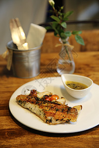 猫吃鱼以木本底为背景的海贝斯片餐厅鲈鱼胡椒蔬菜油炸沙拉午餐食物草药盘子背景