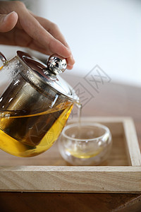 热茶杯 在木制桌上加茶壶饮料蒸汽流感食物桌子草本植物玻璃液体香气咖啡香料图片